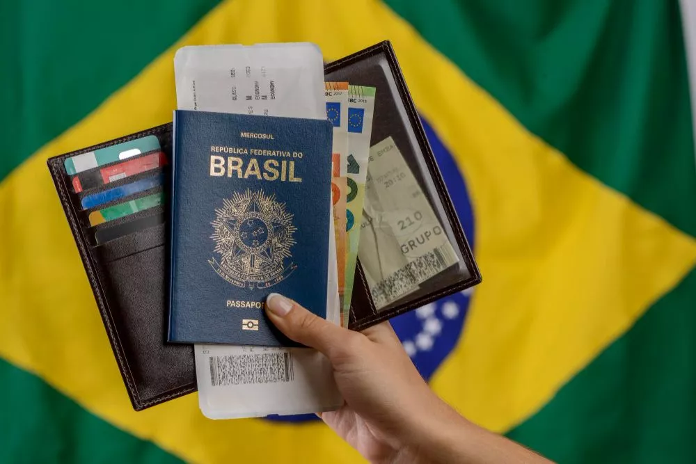 hand-holding-brazilian-passport-with-brazilian-flag-blurred-background